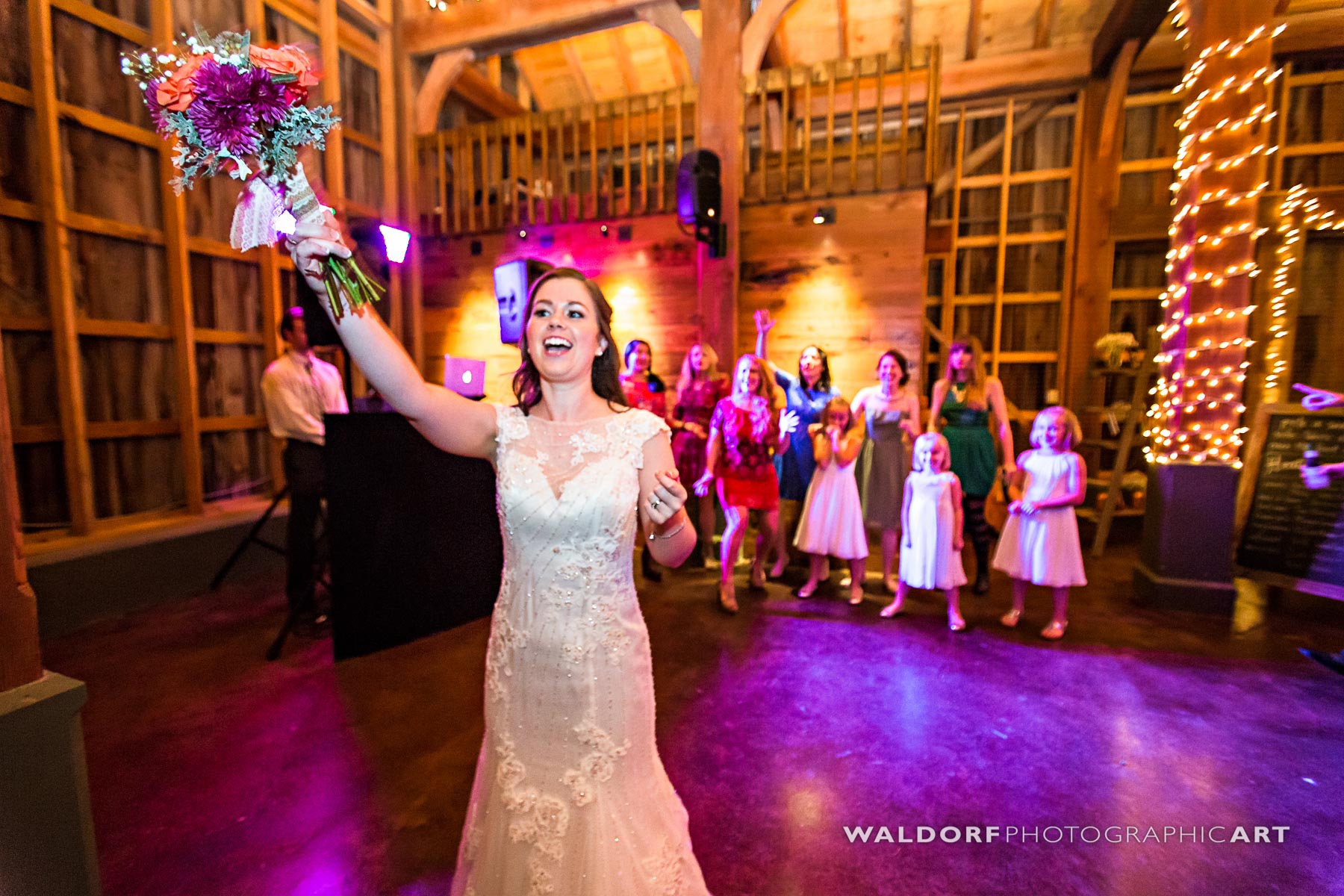 Throwing the bouquet in the barn from above at Pure Water Farm barn wedding near Gatlinburg.